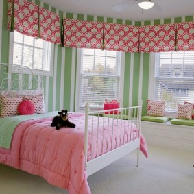 Розовое одеяло на кровати девочки