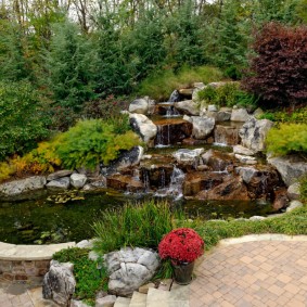 Каменный водопад в саду природного стиля