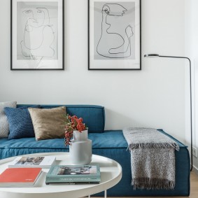 Синий диван под картинами в гостиной