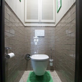 Зеленый коврик на полу в туалете