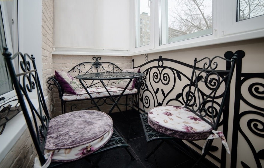 Кованные стульчики на балконе с пластиковыми окнами