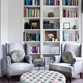 Книжный стеллаж за креслами в комнате