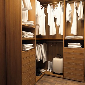 Белые рубашки на вешалках в шкафу