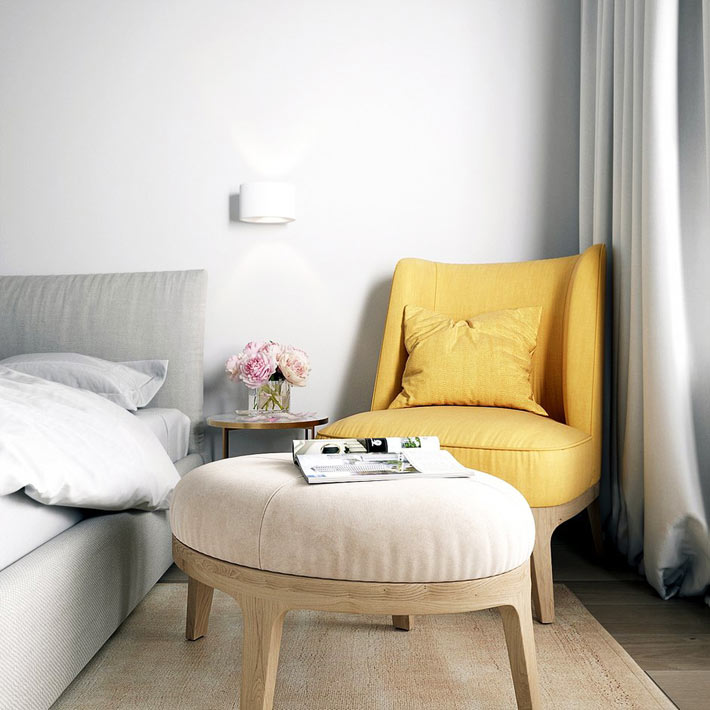 Небольшое кресло желтого цвета в углу спальни